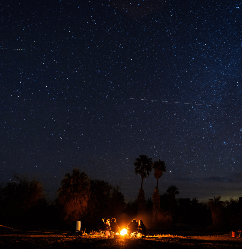 SCA crew members at a camp fire under the night sky in the Mojave desert
