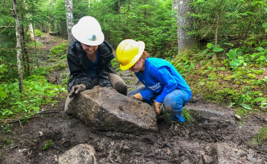 2023 Appalachian Trail Crew Members moving boulders.