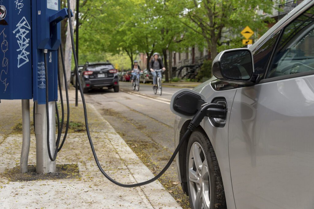 An electric vehicle charges on a residential street. 