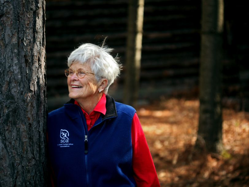 SCA founder Liz Putnam leading against a tree outside