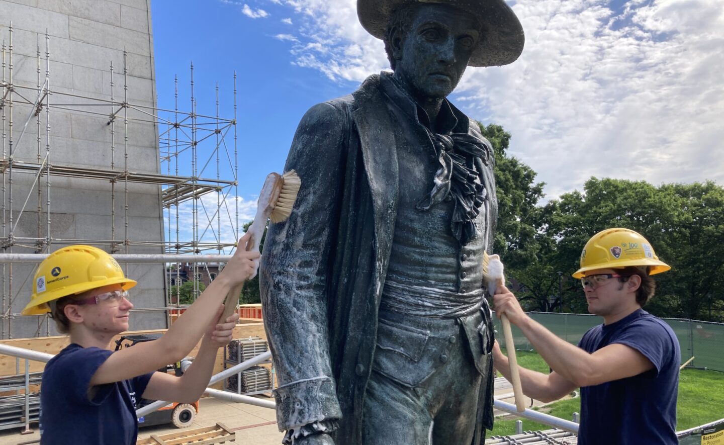 Two crew members from SCA's Massachusetts Historic Preservation Corps work on restoring the statue of Colonel William Prescott at Bunker Hill.