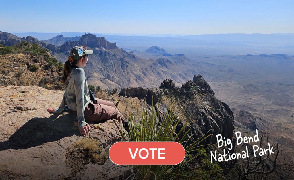Woman sitting on the edge of a cliff wearing long sleeves and a basball cap